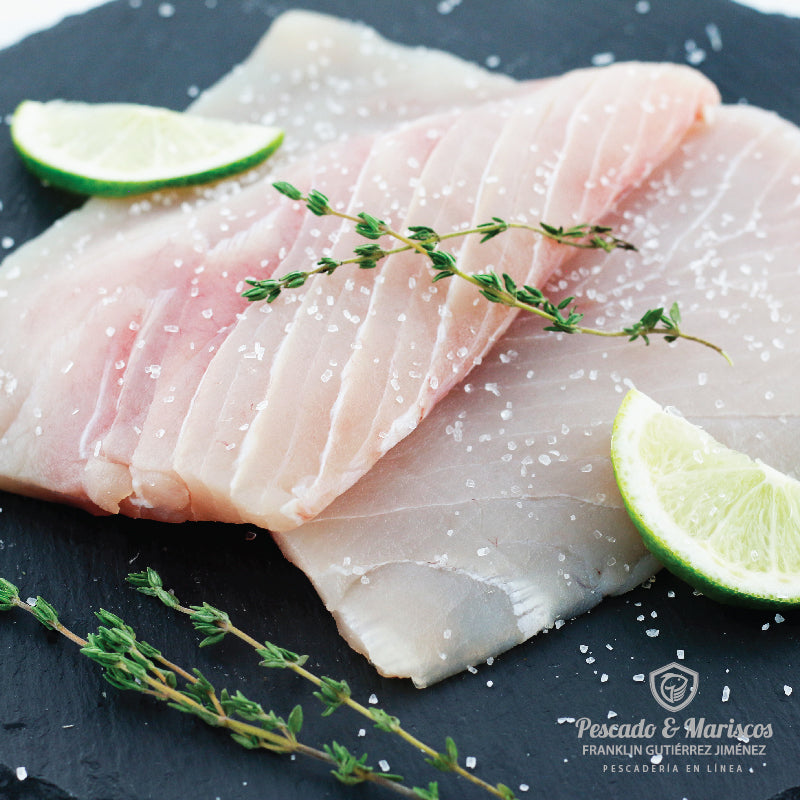 Dos filetes de marlin blanco decorado con ramitas de tomillo y rodajas de limón.