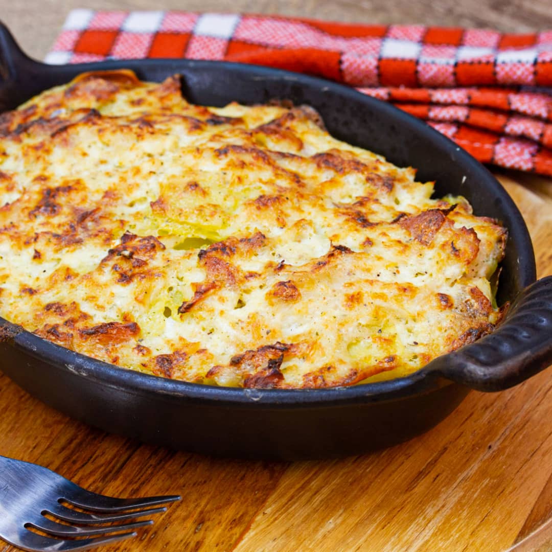 un brandade de congrio con superficie levemente dorada sobre tabla de madera