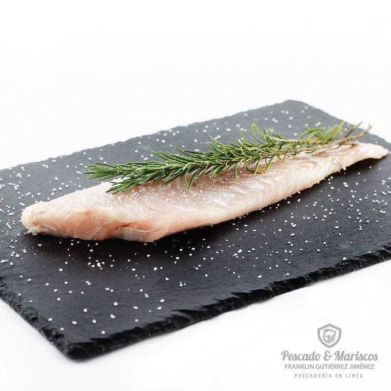 un filete de corvina decorado con una rama de romero.