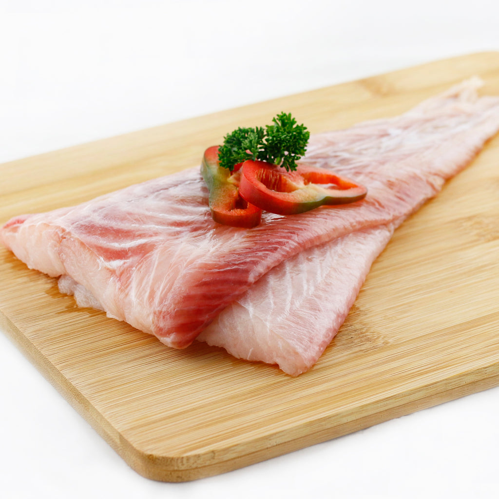 dos filetes de congrio decorados con rodajas de chile pimiento y perejil