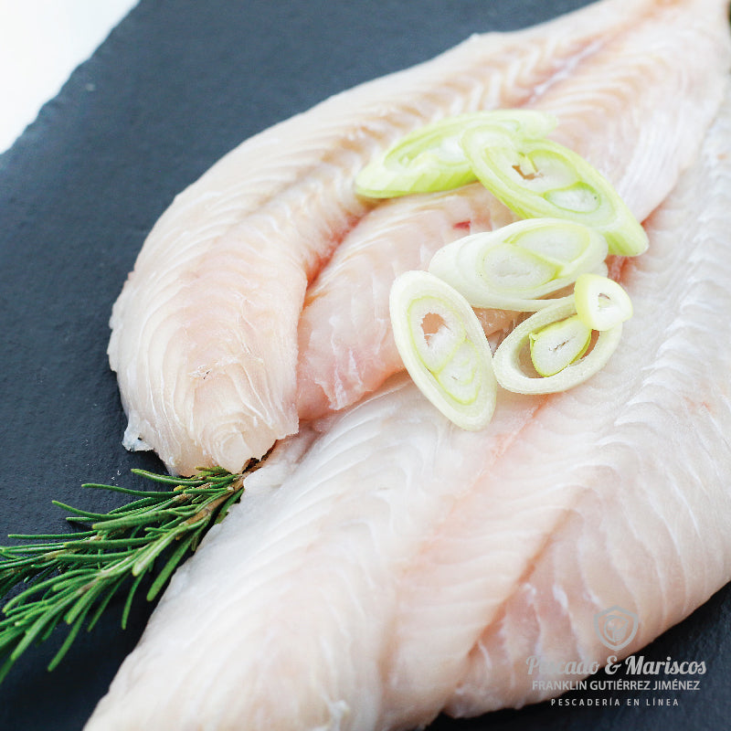 acercamiento de dos filetes de congrio con una rama de romero