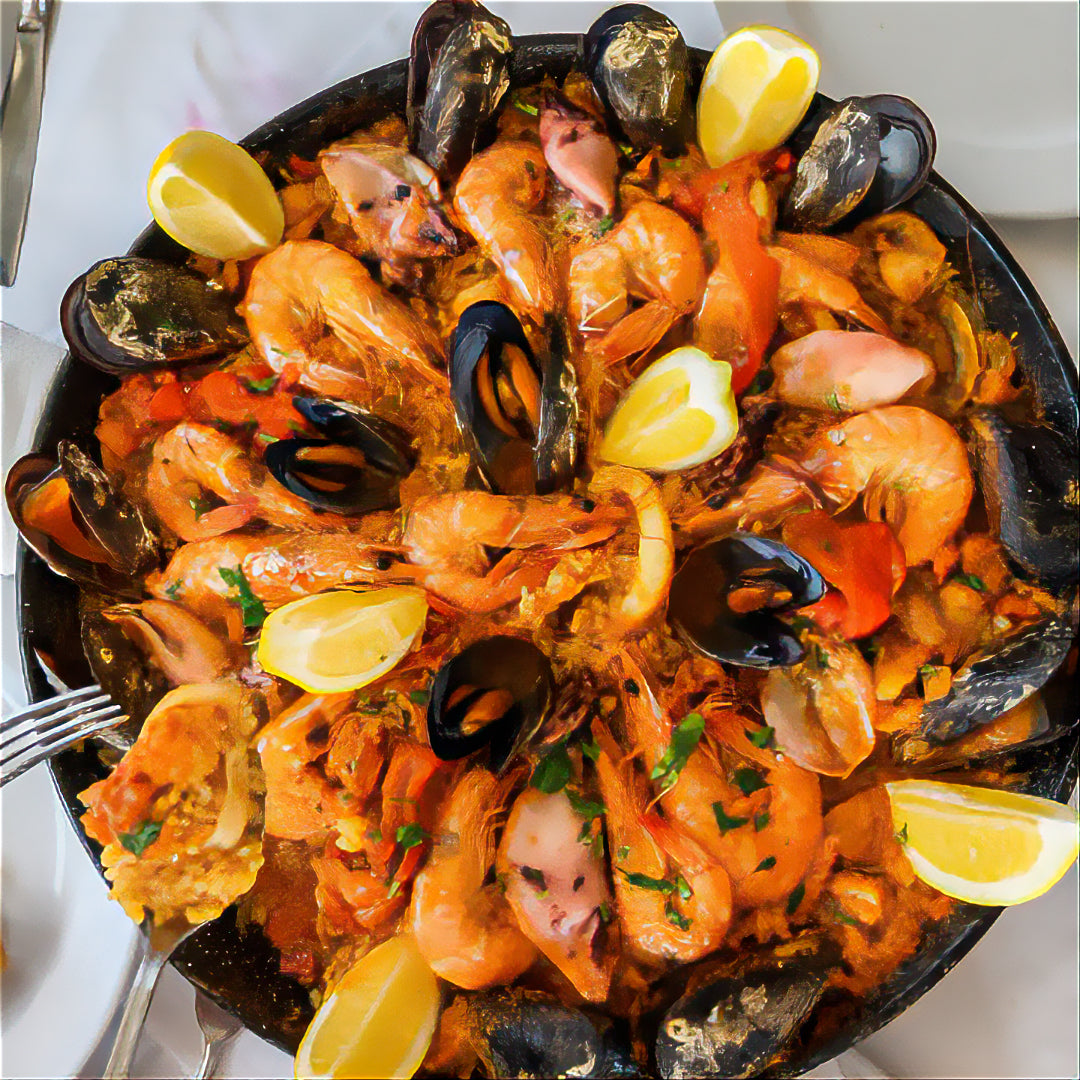 Una paella de mariscos preparado con una mariscada de mejillones, camarones, pescado vela y calamar