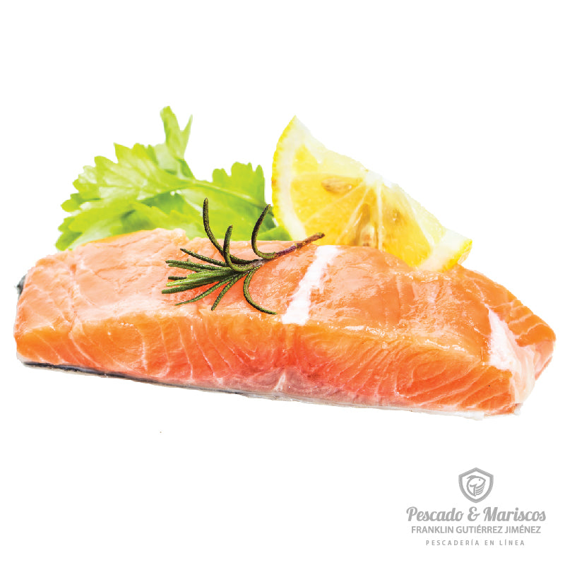 un trozo de salmón decorado con romero, perejil y media rojada de limón